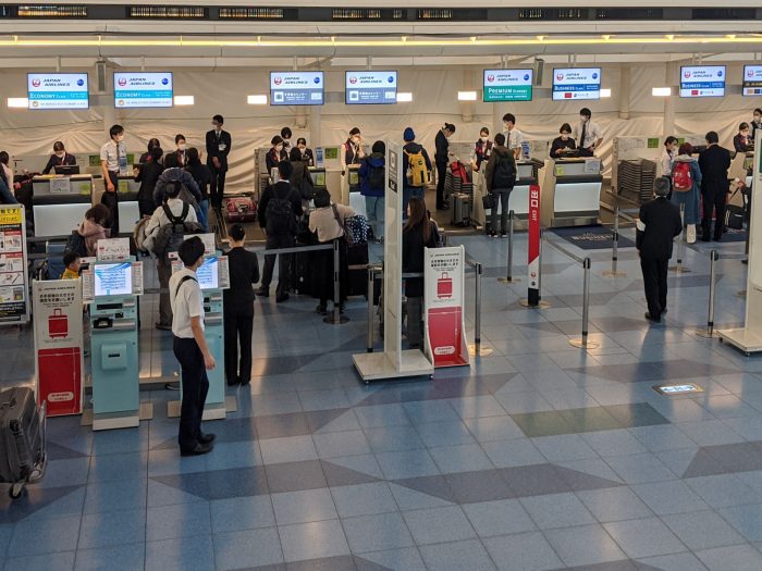 羽田空港・国際線ターミナルの日本航空のチェックインカウンター。スタッフ全員がマスクをしていることがわかる。