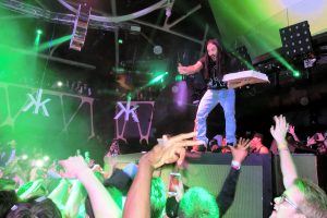 観客に向かってケーキを投げようとしているDJのスティーブ・アオキ氏。