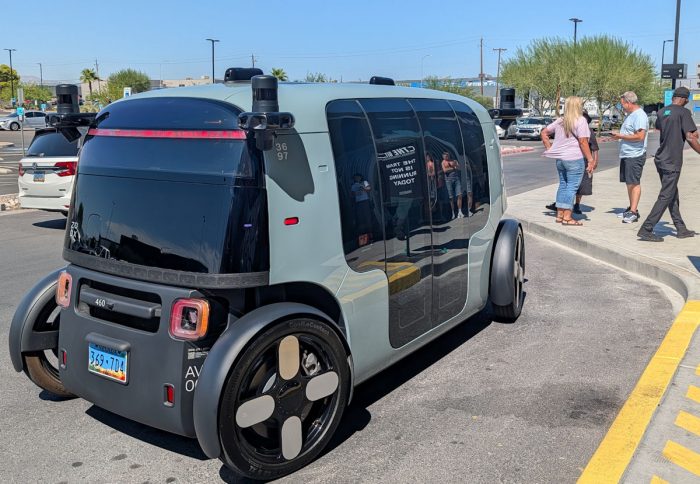 Area 15 の乗降場所。一般車両を自動運転用に改造している Waymo やテスラのロボタクシーとは異なり、ZOOX は専用車両として開発。車体に前後がなく、車内は対面座席になっている。